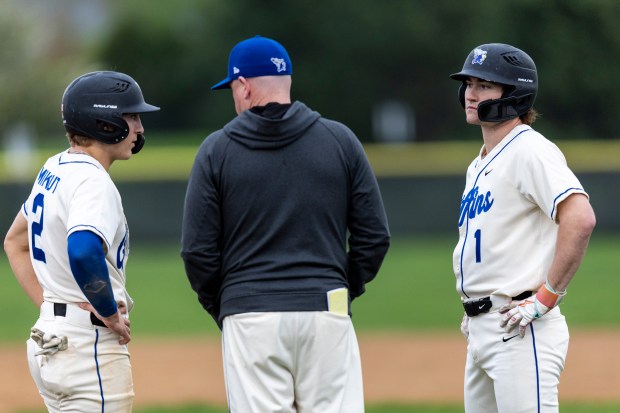Lincoln-Way East's Casey Mikrut (2) and Charlie Cosich (1) talk with head coach John McCarthy mound visit by Providence during a nonconference game in Frankfort on Wednesday, April 30, 2025. (Vincent D. Johnson / for the Daily Southtown)
