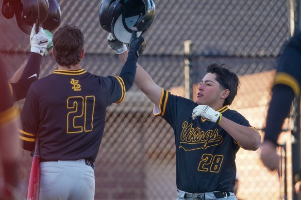 St.Laurence's Adrian Perez (28) is greeted at home by team mates after hitting a two run homer against Mt.Carmel during a Chicago Catholic League conference game at Mt.Carmel High School in Chicago on Thursday, May 8, 2025. (Sean King / for The Daily Southtown)