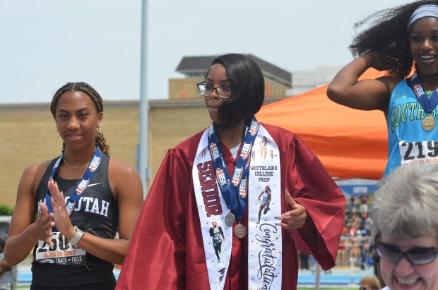 Southland Prep's Kendall Gray wears her graduation gown on the stand after finishing second in the 100 hurdles in the Class 2A girls track state meet at Eastern Illinois in Charleston on Saturday, May 24, 2025. (Jeff Vorva / Daily Southtown)