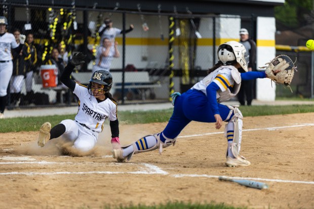 Marian Catholic's Kendyl Rainey (1) slides safely into home against De La Salle during a nonconference game in Chicago Heights on Thursday, May 22, 2025. (Vincent D. Johnson / for the Daily Southtown)