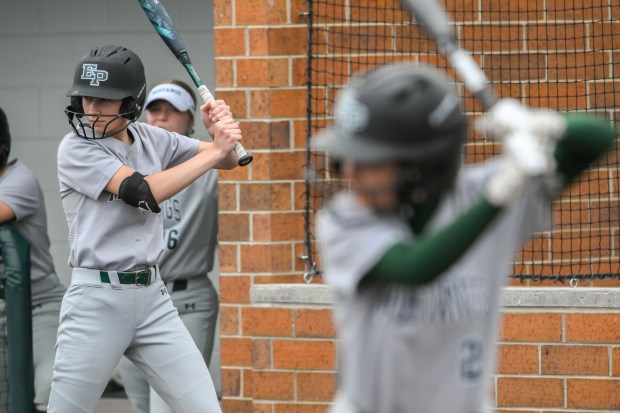 Evergreen Park freshman Molly Goyke (1) warms up on deck behind teammate senior Joie Burns (2, right in foreground) during the Evergreen Park vs. Mansueto class 3A Evergreen Park Regional semifinal in Evergreen Park, IL on Tuesday, May 27, 2025. (Andrew Burke-Stevenson/for the Daily Southtown)