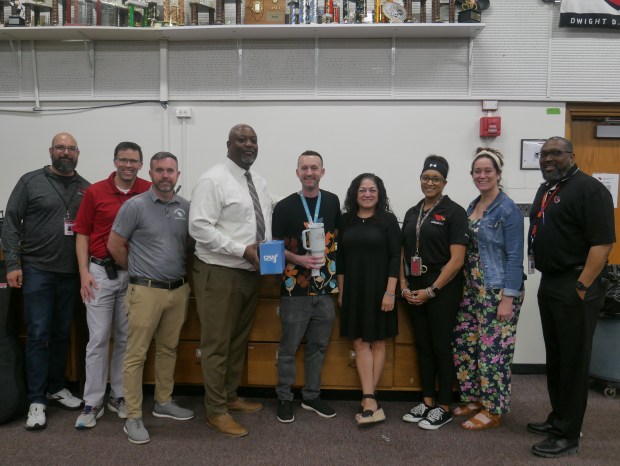 Administrators at Eisenhower High School in Blue Island surprised music teacher Justin Antos with news he won his third CMA Music Teachers of Excellence award on Tuesday, giving him a tumbler mug engraved with the honor. (School District 218)