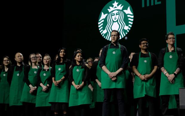 Starbucks baristas stand on stage, March 20, 2019, during an annual shareholders meeting in Seattle. (AP Photo/Ted S. Warren, file)