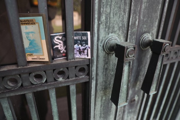 An old Charles Comiskey baseball card and the 2019 White Sox schedule are placed at the grave of Charles Comiskey at Calvary Catholic Cemetery in Evanston on Aug. 30, 2019. (Chris Sweda/Chicago Tribune)