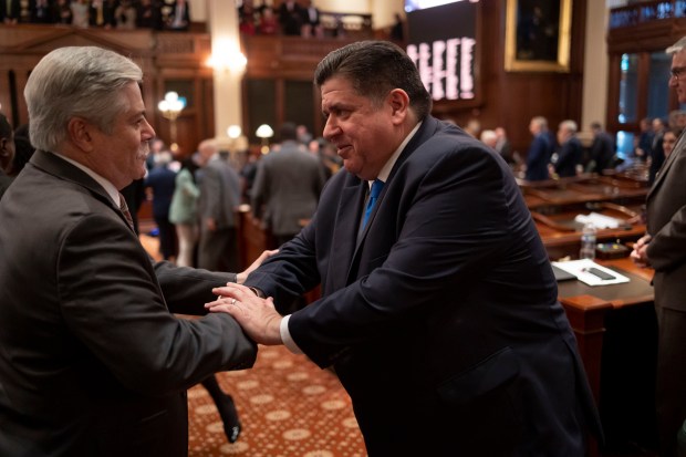 Gov. JB Pritzker greets State Rep. Fred Crespo after delivering his annual budget address to a joint session of the General Assembly on Feb. 15, 2023, at the Illinois State Capitol. (Brian Cassella/Chicago Tribune)