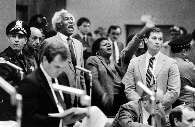 Angry supporters of Mayor Harold Washington jeer the council proceedings after Ald. Ed Vrdolyak seized control of the podium on May 2, 1983. Vrdolyak had taken control of the meeting after Mayor Washington left, and had himself elected vice chairman of the committee during the infamous Council Wars. (Ernie Cox Jr./Chicago Tribune)