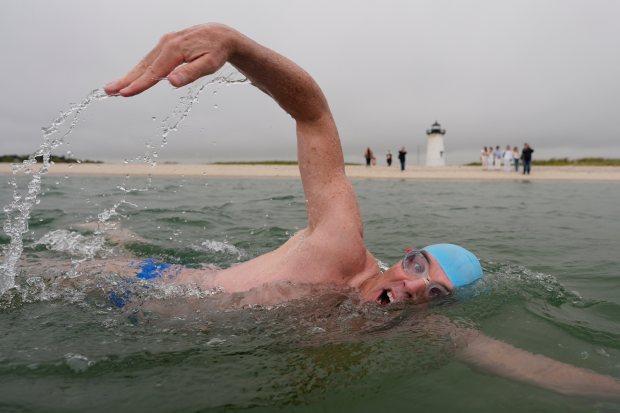 Endurance swimmer Louis Pugh swims near the Edgartown Harbor Light, May 15, 2025, in Edgartown, Massachusetts. He is attempting the first-ever swim around Martha's Vineyard ahead of "Jaws" 50 year anniversary. (Robert F. Bukaty/AP)