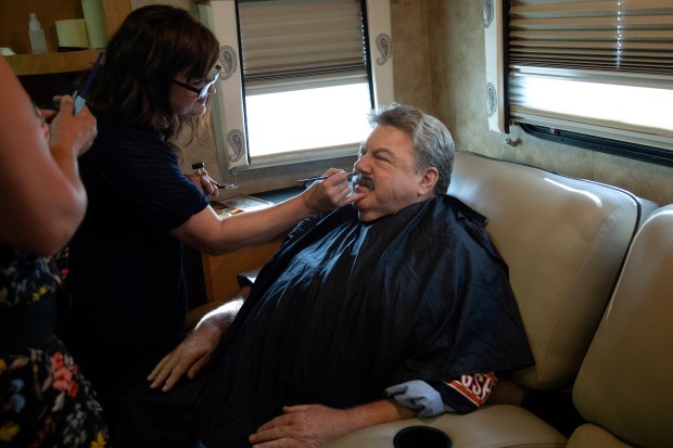 Actor George Wendt gets a fake mustache applied during an interview on Aug. 19, 2019, outside Soldier Field in Chicago. Wendt was filming a segment with actor, writer, producer and director Robert Smigel of "Bill Swerski Super Fans," the "Saturday Night Live" sketch in which they play Bears fans. (Erin Hooley/Chicago Tribune)