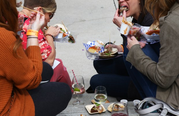 People eat taste portions of foods during Chicago Gourmet at Millennium Park on Sept. 29, 2018. (John J. Kim/Chicago Tribune)