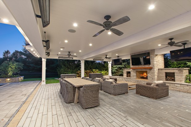The outdoor features of the house at 320 N. 95th Ave., Frankfort, include an in-ground pool, a covered patio with built-in heaters, a misting system, a full kitchen and a fire-pit lounge. (Jamie Zimpelmann)