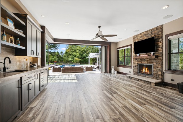 The outdoor features of the house at 320 N. 95th Ave., Frankfort, include an in-ground pool, a covered patio with built-in heaters, a misting system, a full kitchen and a fire-pit lounge. (Jamie Zimpelmann)