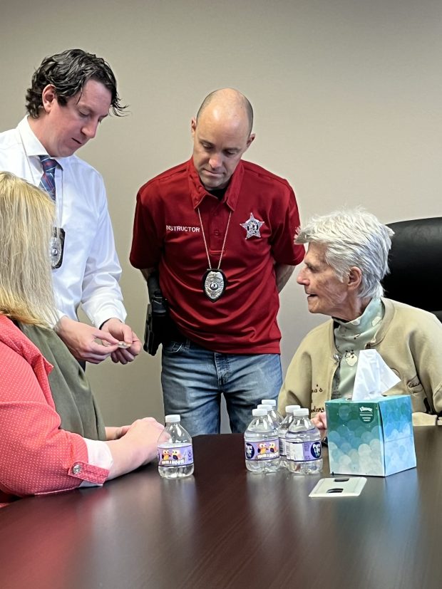 In a photo released by the Elgin Police Department, Elgin police detectives Andrew Houghton and Matt Vartanian, 2nd from right, present items recovered from Karen Schepers' car to her mom, Liz Paulson, right, and sister, Susan Trainer, left. (Elgin Police Department)