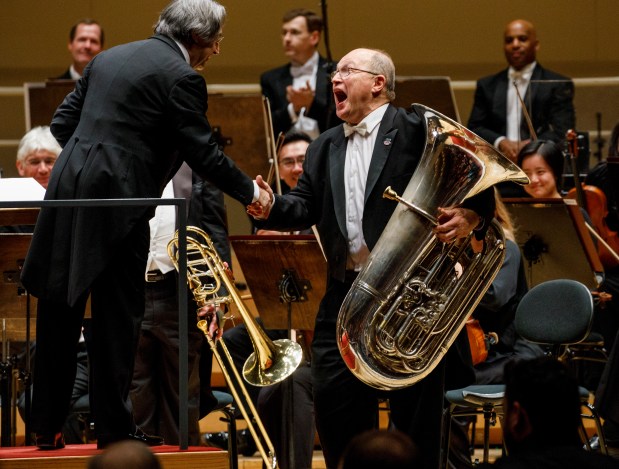 Gene Pokorny, principal tuba player for the Chicago Symphony Orchestra, shakes hands with conductor Riccardo Muti at Symphony Center on Feb. 1, 2018. (Armando L. Sanchez/Chicago Tribune)