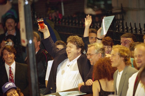 Members of the television show "Cheers," from left, George Wendt, John Ratzenberger, Rhea Perlman, Woody Harrelson, and Kelsey Grammer, toast the crowd outside the Bull and Finch Pub in Boston during the finale of the "Tonight Show" with Jay Leno on May 21, 1993. (Charles Krupa/AP)