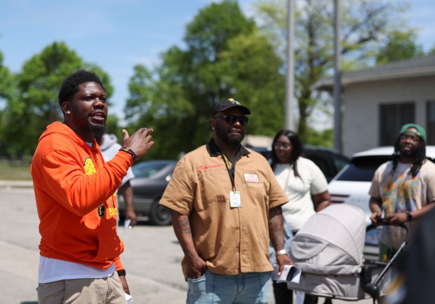 Pha'Tal Perkins, founder of Think Outside Da Block, speaks to members of Outside Da Block and other community nonprofits in the parking lot of the Ogden Park Fieldhouse on May 13, 2025, as they do a walkthrough for their upcoming event Roll N Peace. (Eileen T. Meslar/Chicago Tribune)