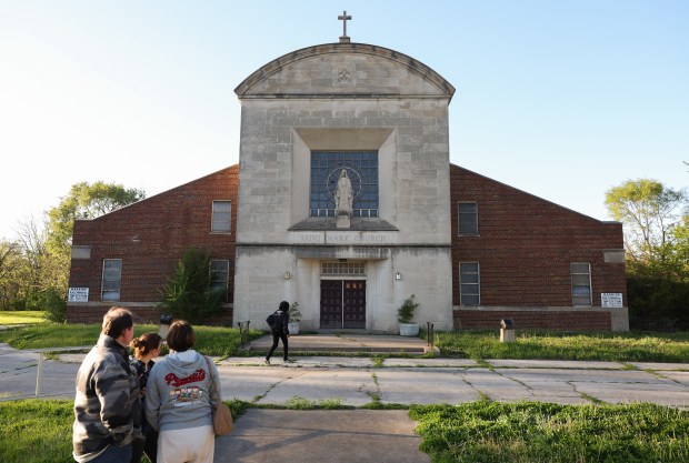 Roxanne Green approaches the front doors of the former St. Mary of the Assumption Church at the corner of South Leyden Avenue and East 137th Street on Thursday, May 8, 2025, in Chicago. New Pope Leo XIV attended the church and parish school while growing up in nearby Dolton. (John J. Kim/Chicago Tribune)
