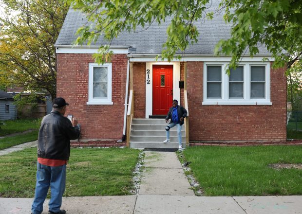 Rosetta Polk has her picture taken in front of the former childhood home of Pope Leo XIV, May 8, 2025, in Dolton. (John J. Kim/Chicago Tribune)