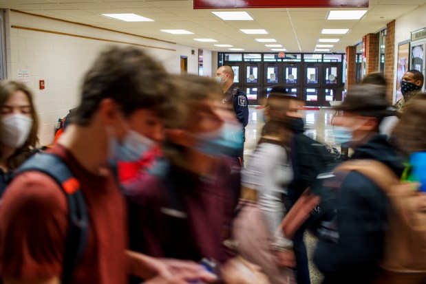 A school resource officer watches students between periods at a high school in downstate Bradley on Jan. 19, 2022. (Armando L. Sanchez/Chicago Tribune)
