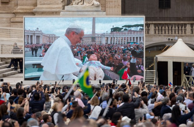 Pope Leo XIV blesses a baby while holding his first general audience, May 21, 2025, in St. Peter's Square at the Vatican. (Brian Cassella/Chicago Tribune)