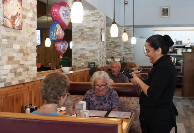 Elsa Garcia takes the lunch order of Barbara Michiels and Nancy Conro, left, at Angel's Pancake Cafe in downtown Hampshire on May 14, 2025. (Stacey Wescott/Chicago Tribune)