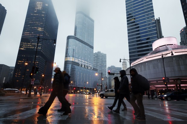 People walk past Trump International Hotel & Tower in Chicago as rain falls on March 7, 2025. A Chicago police officer was suspended after celebrating President Trump's second inauguration at the president's namesake tower, allegedly drinking and then showing up for work. (Terrence Antonio James/Chicago Tribune)