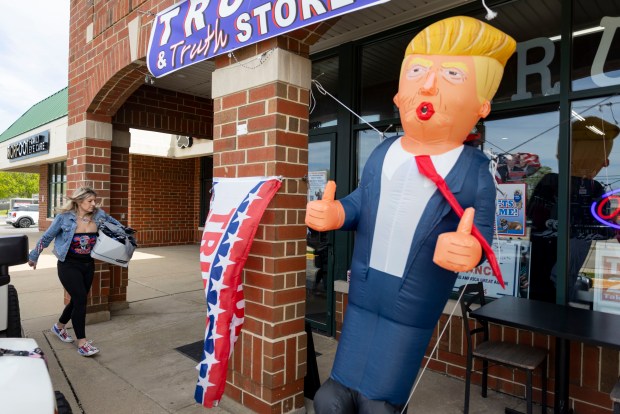 Lisa Fleischmann carries new merchandise into her Trump Truth Store in Huntley. (Brian Cassella/Chicago Tribune)