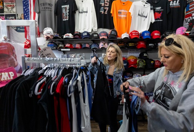 Lisa Fleischmann, center, helps a customer find a shirt at her Trump Truth Store on May 4, 2025. (Brian Cassella/Chicago Tribune)