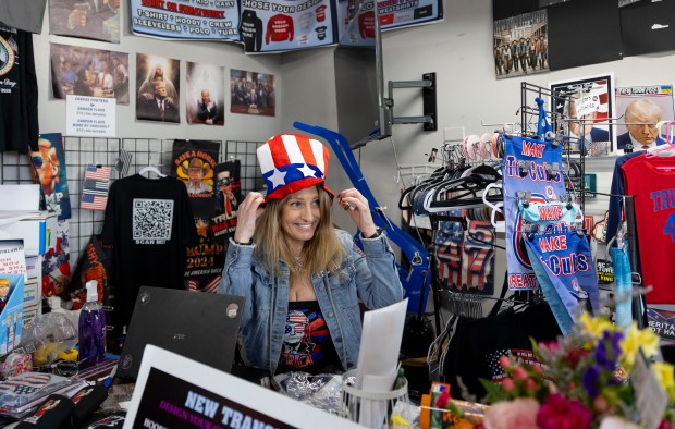 Lisa Fleischmann tries on a hat at her Trump Truth Store, May 4, 2025, in Huntley. (Brian Cassella/Chicago Tribune)