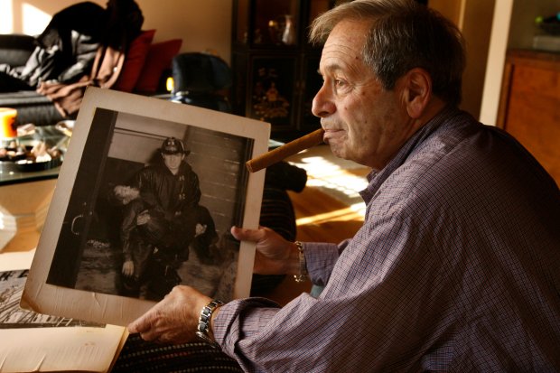Retired photographer Steve Lasker, 78, at his home in Lincolnwood on Nov. 21, 2008, holding a photo he took during the fire at Our Lady of Angels grade school in Chicago on Dec. 1, 1958. One of the worst tragedies in Chicago's history, the fire took the lives of 92 children and three nuns. (Bonnie Trafelet/Chicago Tribune)