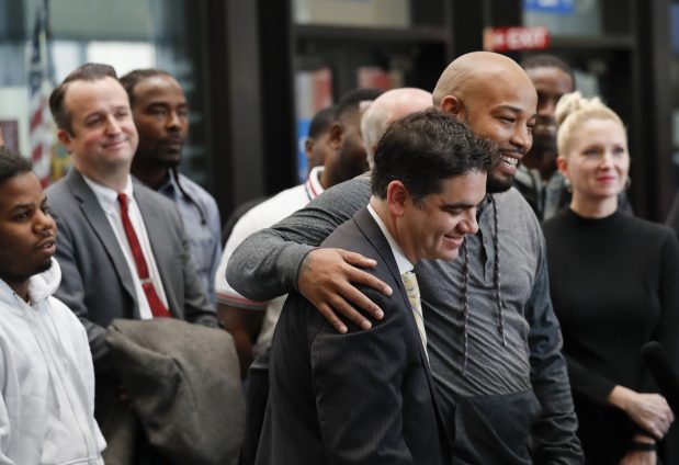 Joshua Tepfer, center, with the Exoneration Project, is hugged by Leonard Gipson as they speak at a news conference at the Leighton Criminal Court Building in Chicago on Nov. 16, 2017. The Exoneration Project filed a consolidated petition requesting the exoneration of 15 men who insisted they were framed by disgraced Sgt. Ronald Watts. (José M. Osorio/Chicago Tribune)