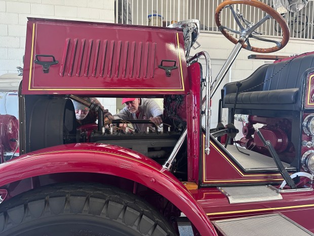 From left, Darrell Hughes and Bob Stadlman inspect the six-cylinder engine of a restored 100-year-old fire truck named Old Number One. (Yadira Sanchez Olson/For the Lake County News-Sun)