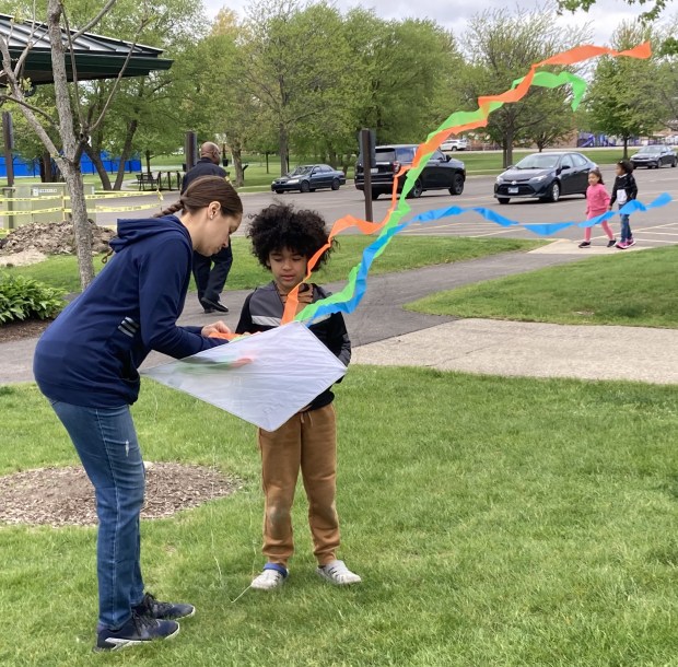 A mother helps her son fly a kite. (Steve Sadin/For the Lake County News-Sun)