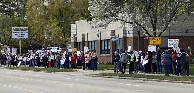 Demonstrators hold signs in front of the Social Security Administration building in Waukegan. (Steve Sadin/For the Lake County News-Sun)