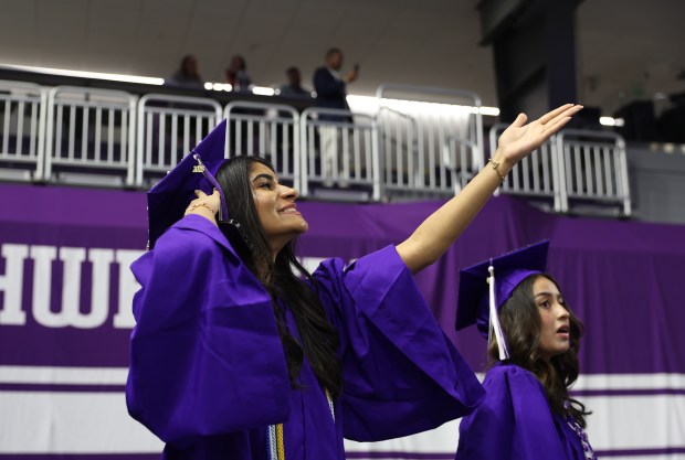 A graduate gestures towards the stands while filing into Welsh-Ryan Arena during the Niles North High School graduation at Welsh-Ryan Arena in Evanston on Sunday, May 25, 2025. (Talia Sprague / Pioneer Press)