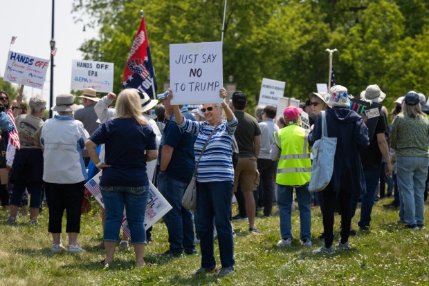 Nancy Kotlarz joins others protesting against supporters of Truth Trump Store, owned by Lisa Fleischmann, staying open about a half of a mile away from the store and across the street on Saturday, May 31, 2025, in Huntley. (Audrey Richardson/Chicago Tribune)