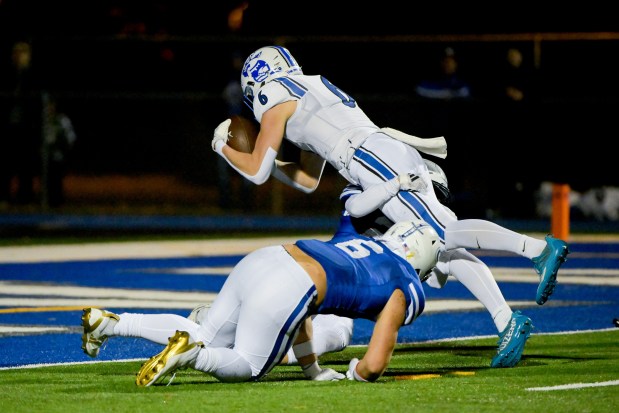 St. Charles North's Keaton Reinke (6) leaps into the end-zone for a touchdown at Geneva on Friday, Oct. 25, 2024. (Mark Black / for the Beacon-News)