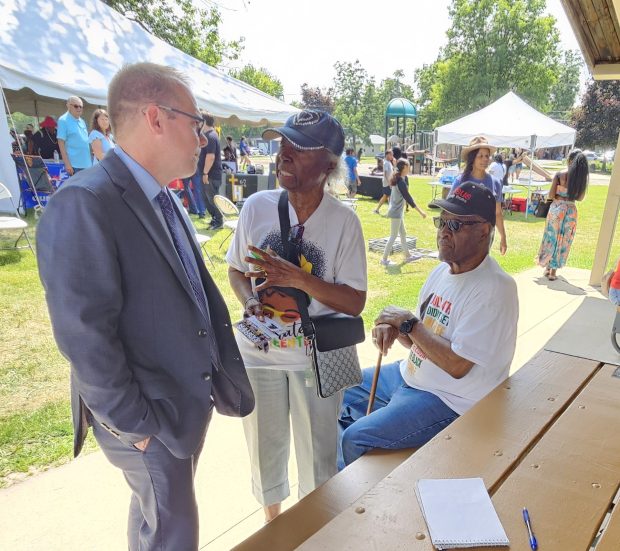 Aurora Mayor John Laesch speaks with visitors Saturday at Dr. Martin Luther King Jr. Park in Aurora during a Juneteenth celebration. (David Sharos / For The Beacon-News)