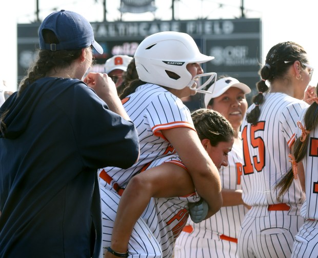 After hitting a home run in the third inning, Oswego's Aubriella Garza (12) rides on the shoulders a her teammates as she returns to the dugout. Oswego defeated Barrington 4-1 in the Class 4A championship game at the Louisville Slugger Sports Complex in Peoria, Saturday, June 14, 2025. (Rob Dicker / for the Beacon News)