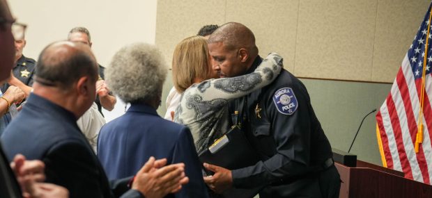 Keith Cross gets a hug from his wife Deanna at a farewell celebration for the retiring chief of the Aurora Police Department that was held Thursday afternoon at the APD headquarters (Aurora Police Department)