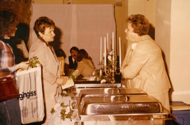 Charleen Reuland, right, who co-founded Reuland Food Services 70 years ago with husband Paul, visits with a guest at a wedding expo in 1976. (Reuland Food Services)