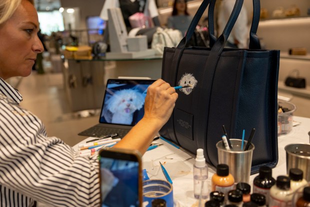 Artist Erika Vazzana paints pet portraits on handbags inside the Marc Jacobs store on June 1, 2025, during the 28th annual Angels With Tails adoption event by PAWS Chicago in the Gold Coast neighborhood. (Brian Cassella/Chicago Tribune)