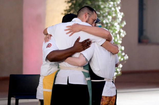 Local Chicago chef César Murillo, center, embraces other finalists, including Bailey Sullivan, during the filming of "Top Chef." (David Moir/Bravo)