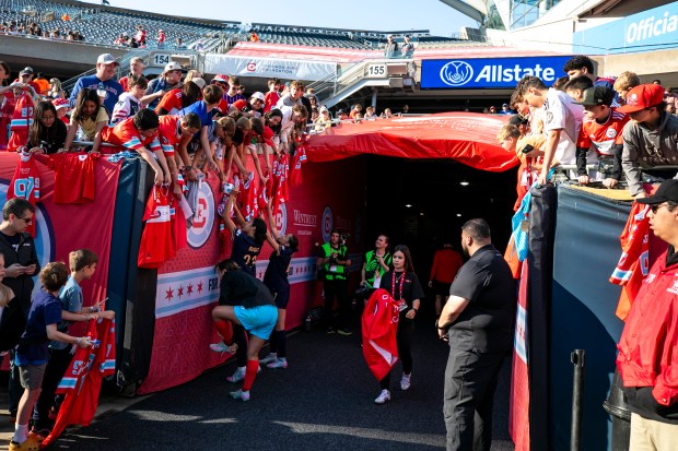 Young fans hang over the railing where Fire and Stars players left and entered the field Saturday, June 14, 2025, at Solder Field. (Vincent D. Johnson/for the Chicago Tribune)