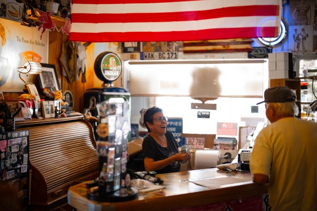 Hackberry General Store clerk Eva Rodriguez jokes with a regular customer at the longtime Route 66 destination in Hackberry, Arizona, June 6, 2025. (E. Jason Wambsgans/Chicago Tribune)