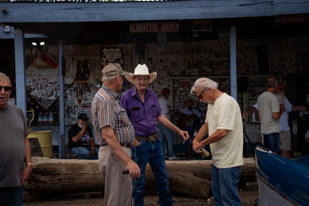 Friends from a local car club along with tourists passing through town mingle outside the Hackberry General Store on Route 66 in Arizona on June 6, 2025. (E. Jason Wambsgans/Chicago Tribune)