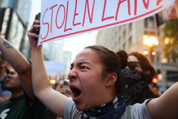 A demonstrator yells a chant at police during a rally and march in the Loop against nationwide immigration raids by federal law enforcement, June 10, 2025, in Chicago. (John J. Kim/Chicago Tribune)