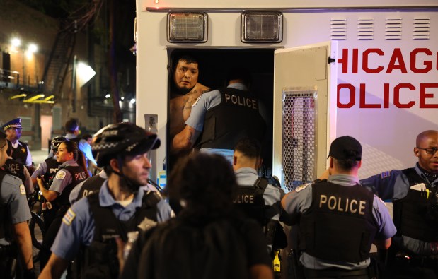 A demonstrator is detained on Dearborn Street as he is placed in a police vehicle as people rally and march in downtown Chicago in response to nationwide immigration raids by federal law enforcement, June 10, 2025. (Chris Sweda/Chicago Tribune)