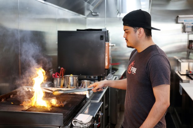 KFire employee Alexis Ortiz, cooks an order of kalbi beef at on June 2, 2025. The food delivery company Grubhub gave the restaurant an "Established 2020" award because it was started during COVID and made it to its fifth anniversary. Ortiz has been with the company since the beginning. (Terrence Antonio James/Chicago Tribune)