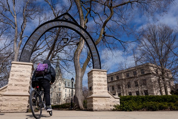 A bicyclist passes by the arch on the Northwestern University campus on March 31, 2025, in Evanston. (Brian Cassella/Chicago Tribune)