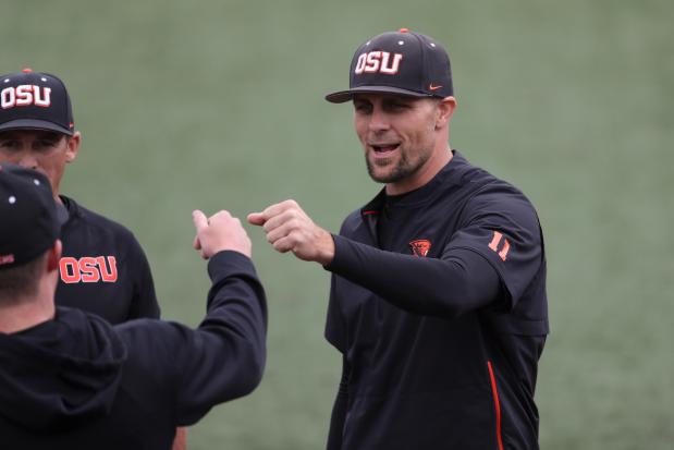 Oregon State head coach Mitch Canham fist bumps players during introductions before a game against Auburn on June 13, 2022, in Corvallis, Ore. (AP Photo/Amanda Loman)